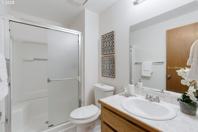 bathroom featuring an enclosed shower, vanity, and toilet