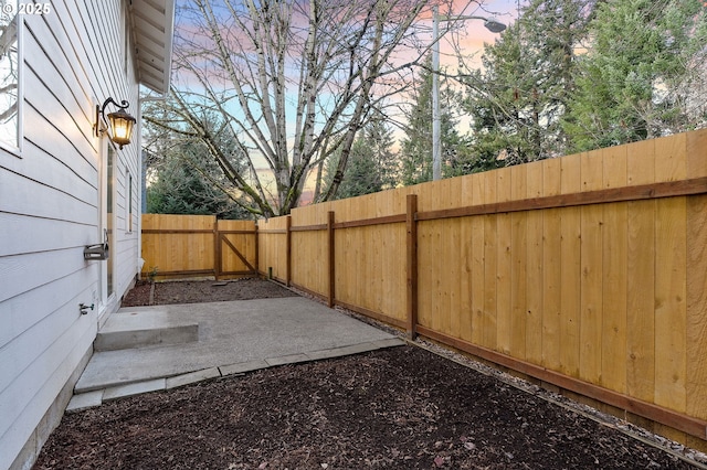 yard at dusk featuring a patio area