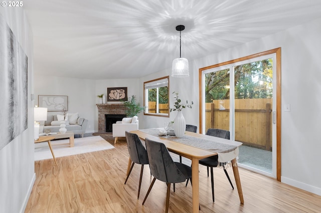 dining area with a fireplace and light hardwood / wood-style floors