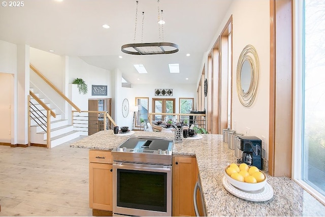 kitchen featuring black cooktop, electric stove, oven, light stone counters, and light hardwood / wood-style flooring