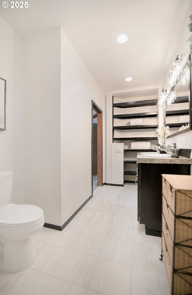 bathroom featuring toilet, tile patterned floors, and vanity