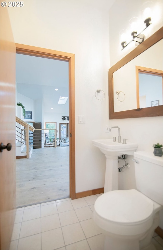 bathroom featuring toilet, a skylight, and tile patterned flooring