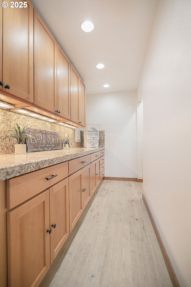 interior space featuring light brown cabinetry, backsplash, and light hardwood / wood-style flooring