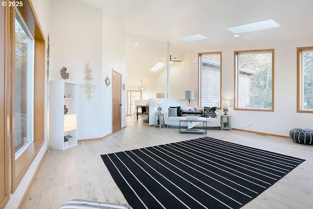 living room featuring hardwood / wood-style flooring, a skylight, and ceiling fan