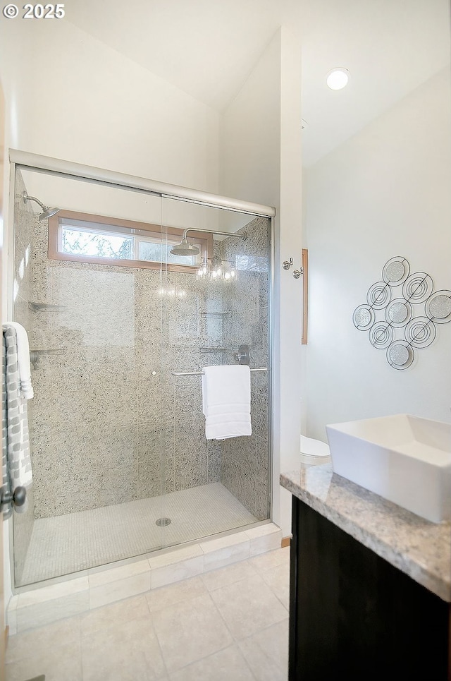 bathroom featuring tile patterned floors, vanity, and a tile shower