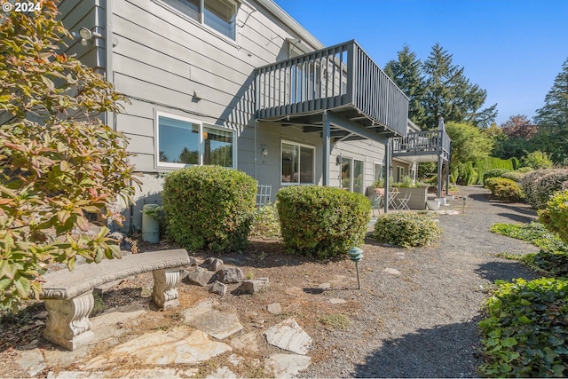 rear view of house featuring a wooden deck and a patio