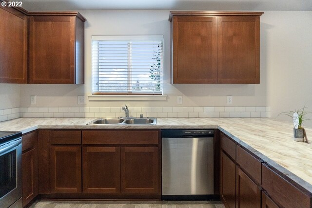 kitchen with appliances with stainless steel finishes, a sink, and light countertops