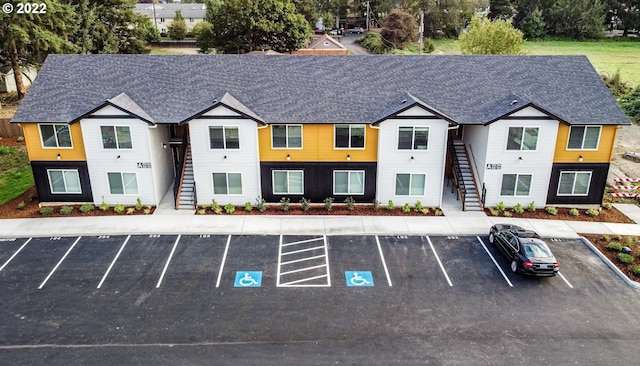 view of property featuring stairs and uncovered parking
