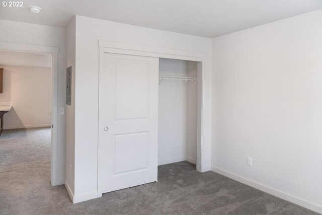 unfurnished bedroom featuring carpet, a closet, and baseboards