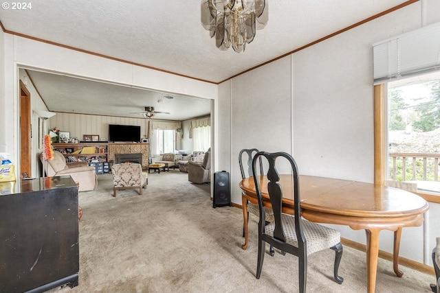 carpeted dining room featuring a textured ceiling, crown molding, and ceiling fan