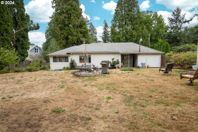 back of house with a yard and a fire pit