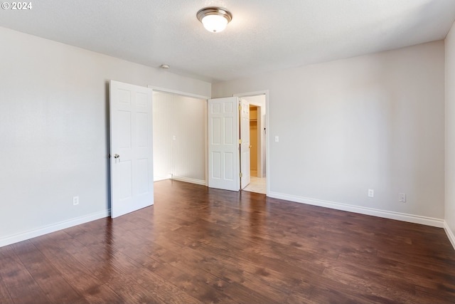 spare room with dark hardwood / wood-style flooring and a textured ceiling