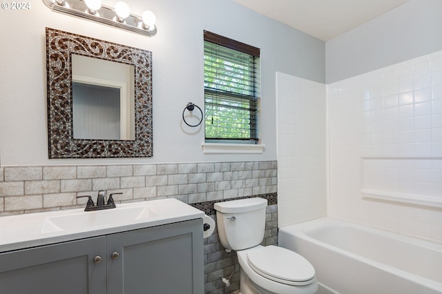 full bathroom featuring vanity, toilet, tile walls, and bathtub / shower combination