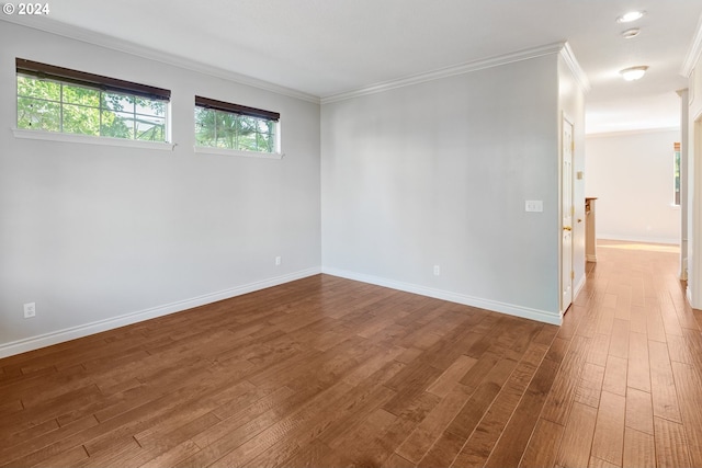 empty room featuring crown molding and wood-type flooring