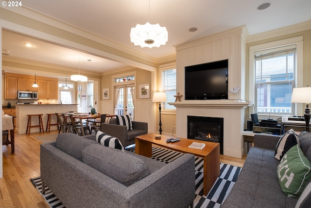 living room with light wood-style floors, french doors, a fireplace, and plenty of natural light