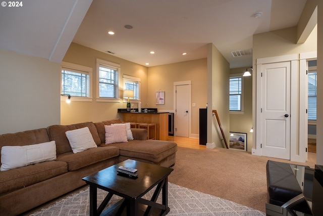 living area featuring light carpet, recessed lighting, visible vents, and a healthy amount of sunlight