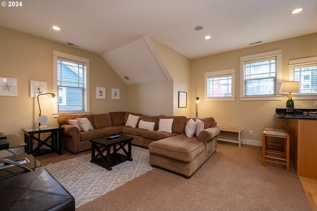 carpeted living room featuring vaulted ceiling