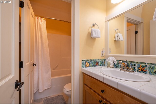 full bathroom with shower / tub combo, tile patterned flooring, toilet, and vanity