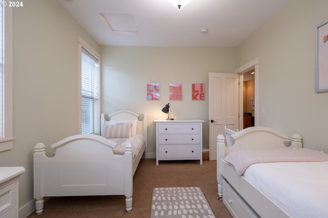 bedroom featuring attic access and carpet flooring