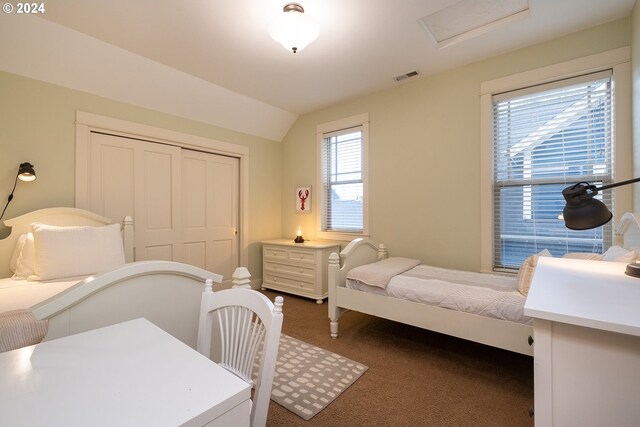 bedroom featuring a closet, lofted ceiling, and carpet flooring