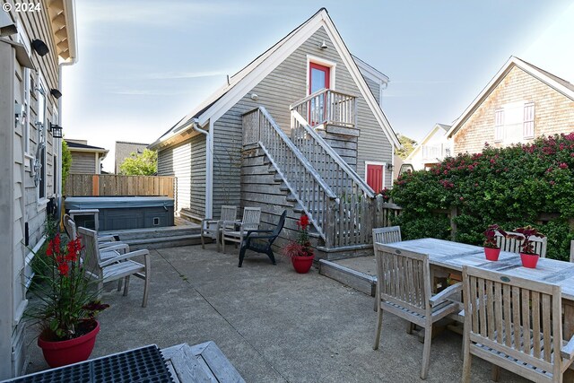 back of house featuring a hot tub and a patio area