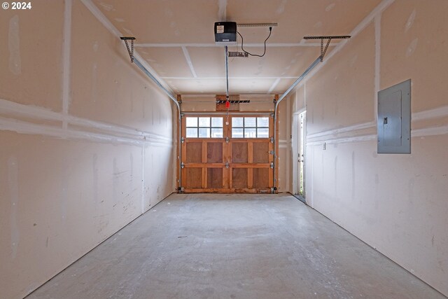 garage with a garage door opener and electric panel