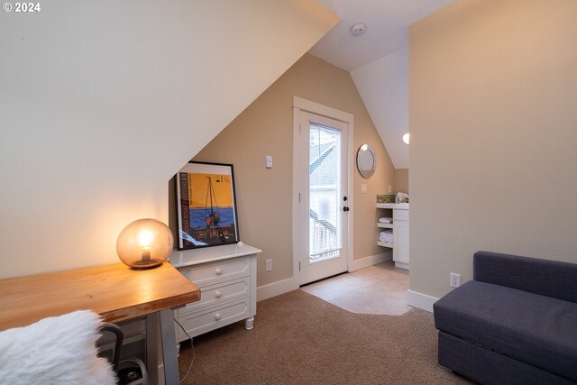 sitting room with vaulted ceiling, light carpet, and plenty of natural light