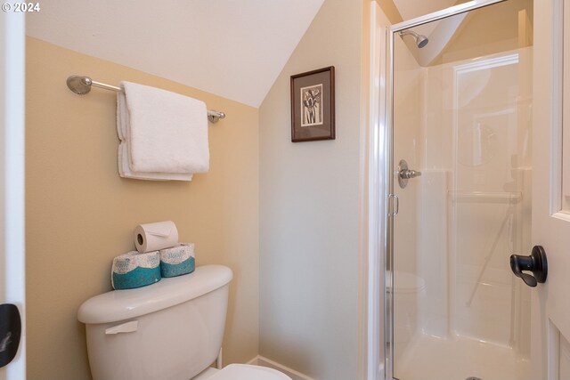 bathroom with an enclosed shower, vaulted ceiling, and toilet