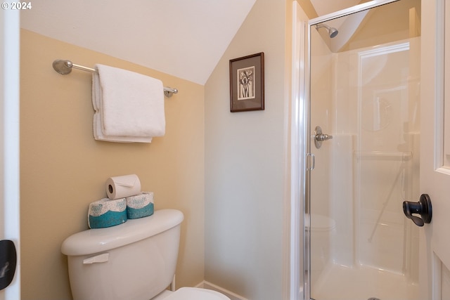 bathroom featuring lofted ceiling, a stall shower, and toilet