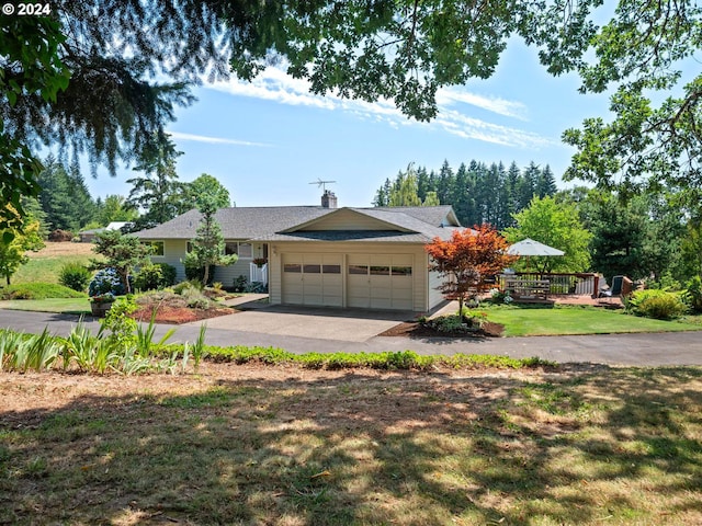 view of front facade featuring a garage, a deck, and a front lawn