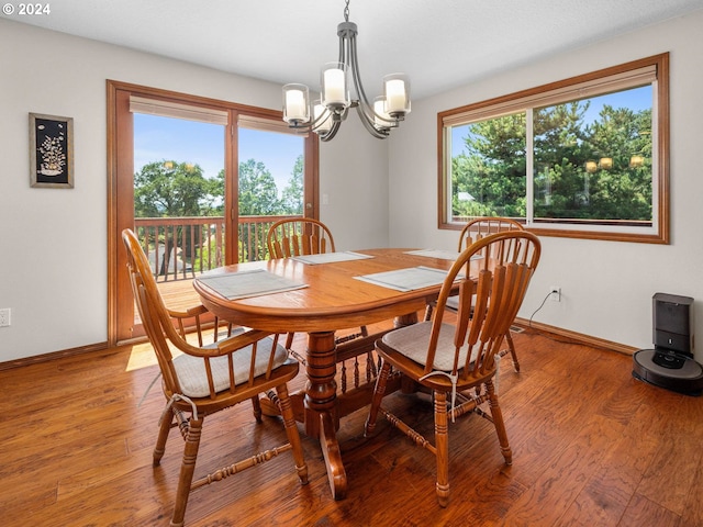 dining room with hardwood / wood-style floors and a notable chandelier