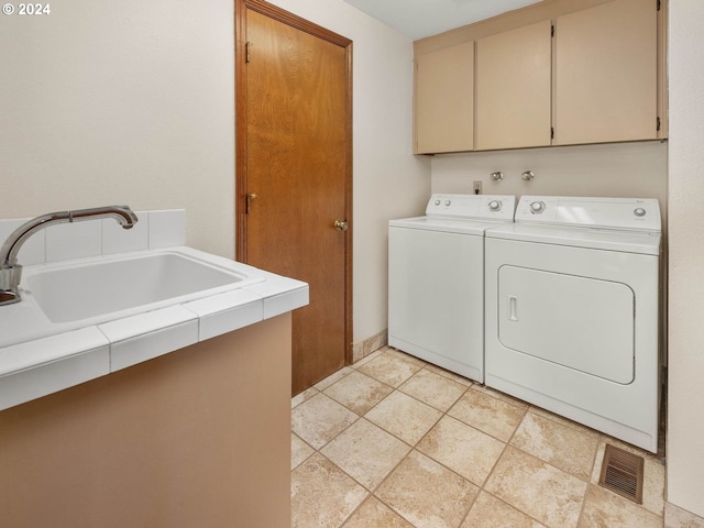 washroom featuring cabinets, washer and dryer, and sink