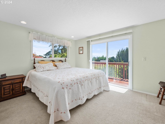 bedroom featuring access to exterior, light carpet, and a textured ceiling