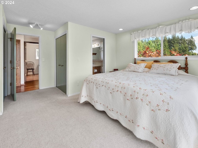 bedroom featuring connected bathroom, a closet, and carpet floors