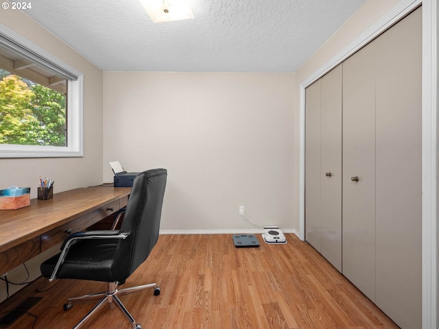 office area featuring a textured ceiling and light wood-type flooring