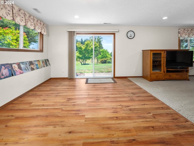 unfurnished living room featuring light carpet and a textured ceiling