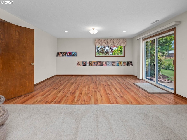 interior space featuring light hardwood / wood-style flooring and a textured ceiling