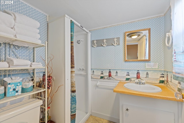 bathroom with a shower with shower door, crown molding, and vanity