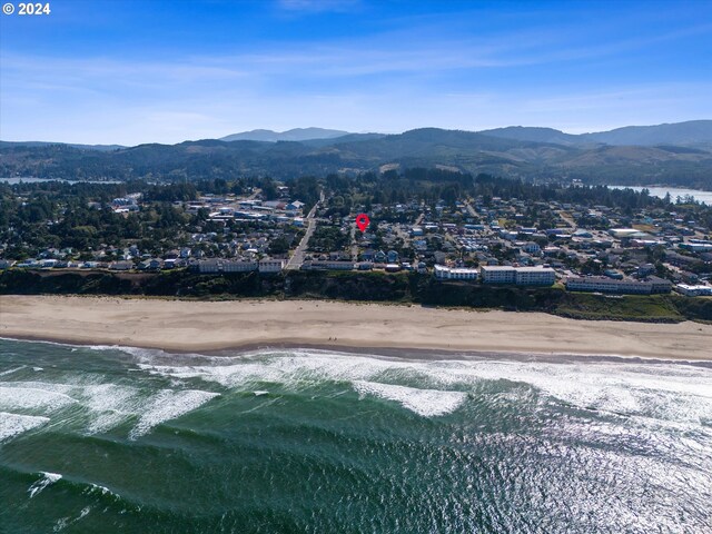 birds eye view of property with a water and mountain view and a beach view