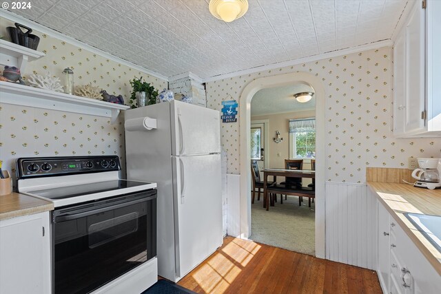 kitchen featuring ornamental molding, white appliances, white cabinets, and carpet floors