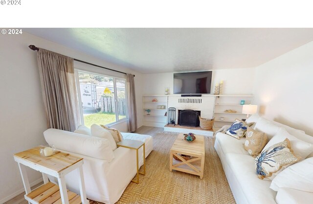 living room featuring a brick fireplace and light hardwood / wood-style flooring