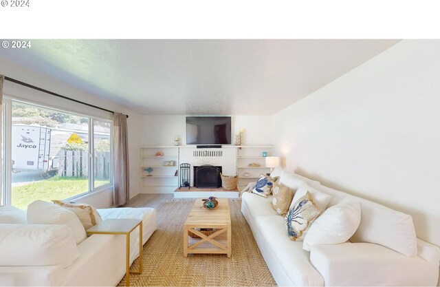 living room with wood-type flooring and a brick fireplace