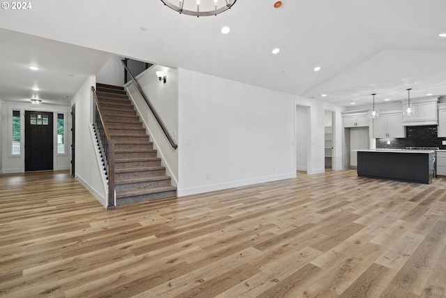 unfurnished living room featuring light wood-type flooring and vaulted ceiling