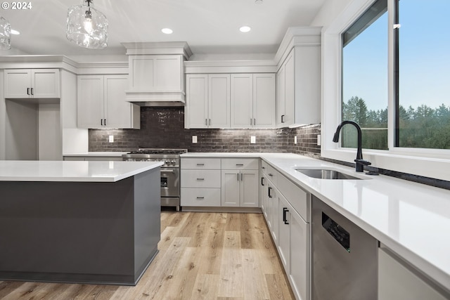 kitchen featuring decorative light fixtures, sink, plenty of natural light, and stainless steel appliances