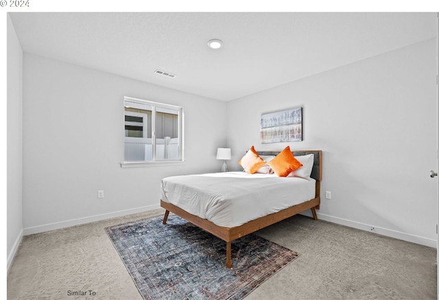 carpeted bedroom featuring baseboards and visible vents