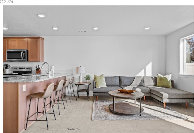 living area with recessed lighting, visible vents, and concrete flooring