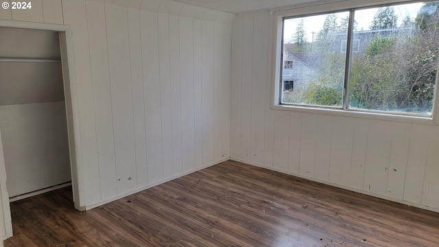 unfurnished bedroom featuring lofted ceiling, dark wood-type flooring, and multiple windows