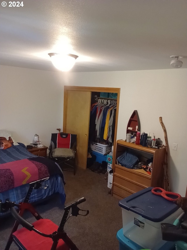 carpeted bedroom featuring a textured ceiling and a closet