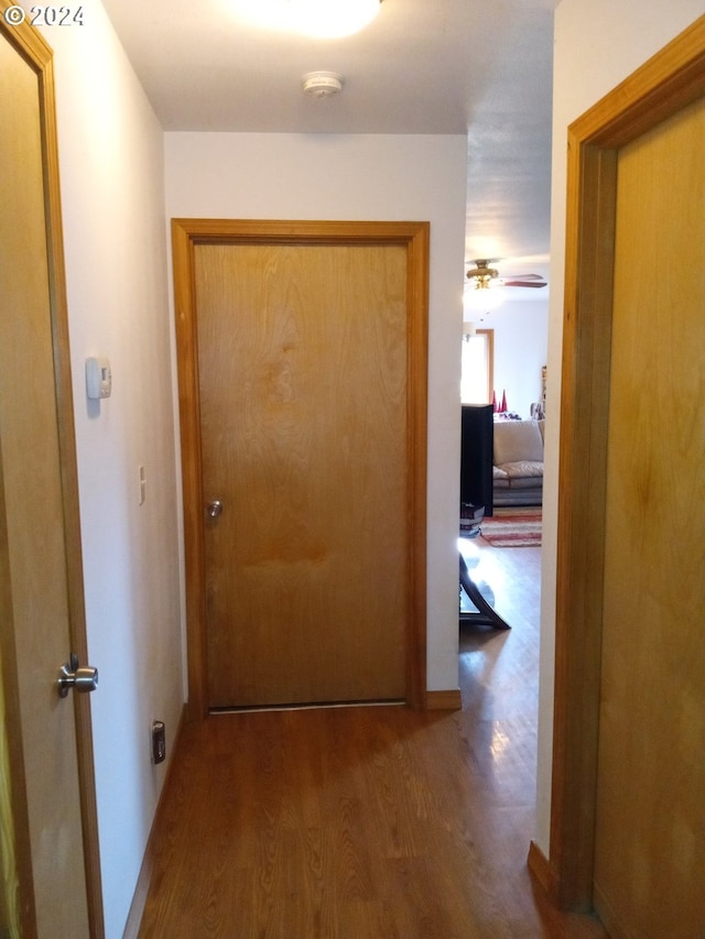 corridor with hardwood / wood-style flooring