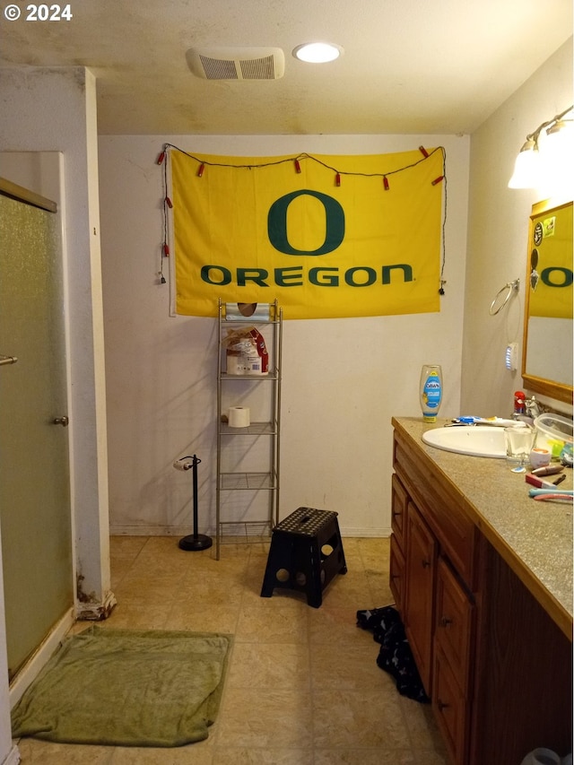 bathroom featuring tile patterned flooring, vanity, and walk in shower